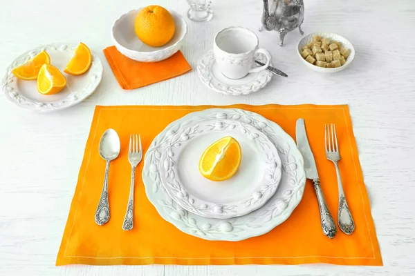 Table setting with orange napkin — Stock Photo, Image