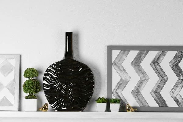 Modern vase with picture on shelf in room — Stock Photo, Image