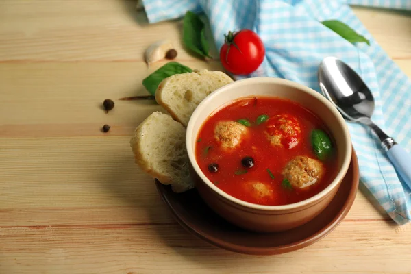 Tomato soup with meat balls on wooden spoon on wooden background — Stock Photo, Image