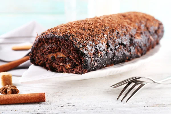 Delicioso rollo de chocolate con especias en la mesa de madera, primer plano — Foto de Stock