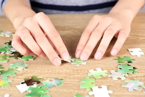 Weibliche Hände beim Zusammensetzen von Puzzle — Stockfoto