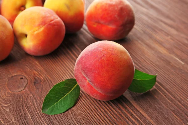 Fresh peaches on wooden table, closeup — Stock Photo, Image