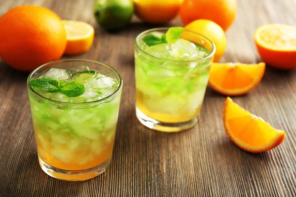 Kireç suyu ile portakal ahşap masa, closeup üzerinde gözlük — Stok fotoğraf