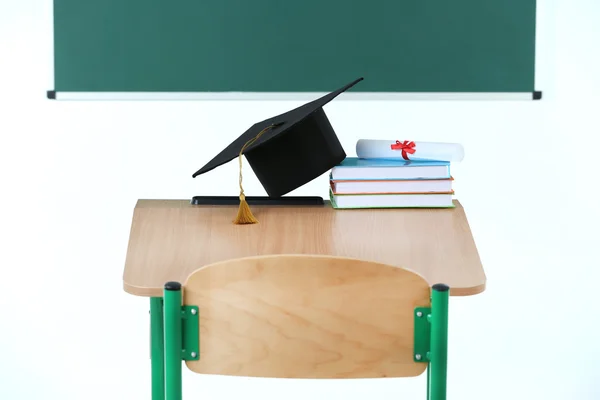 Escritorio de la escuela con sombrero maestro —  Fotos de Stock