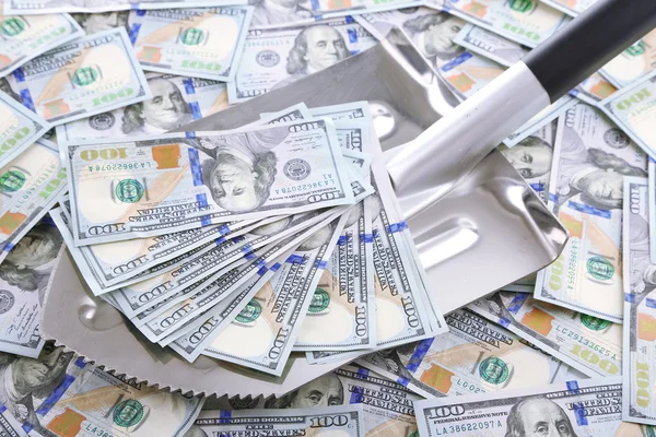 Shovel lifts dollar bills — Stock Photo, Image