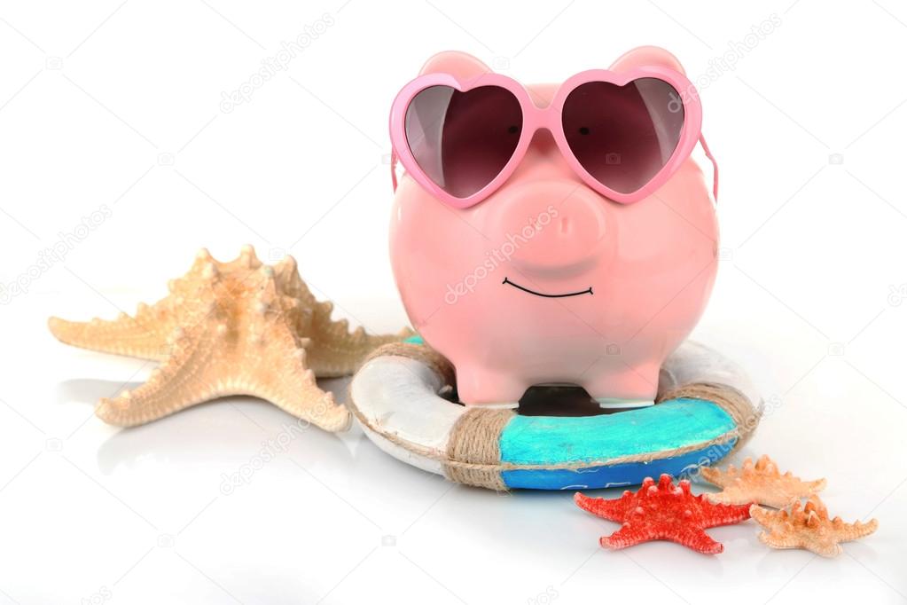 Pink piggy bank in sunglasses with starfishes