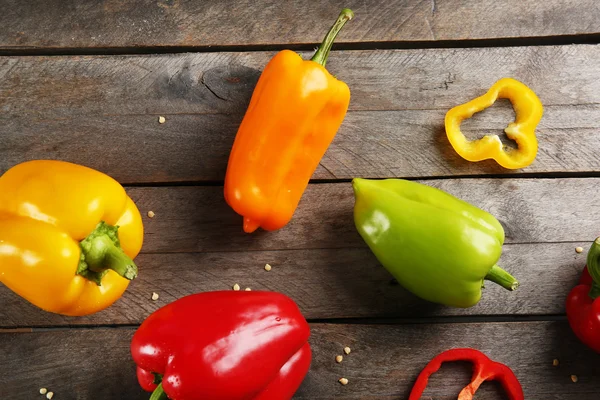 Pimentos coloridos na mesa de madeira rústica — Fotografia de Stock