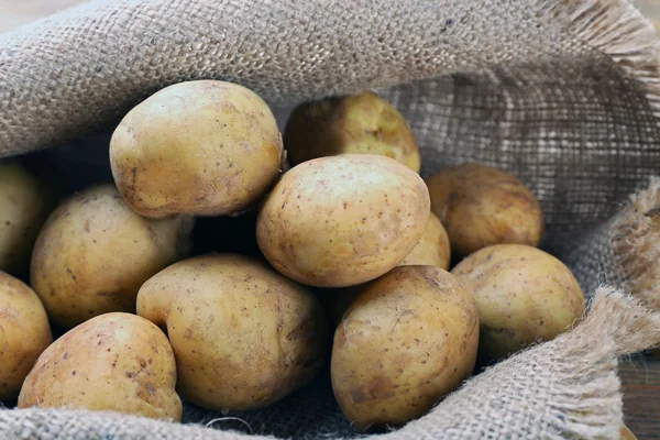 Jonge aardappelen op zak close-up — Stockfoto
