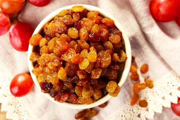 Raisins in bowl with grapes — Stock Photo, Image