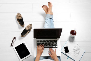 dizüstü bilgisayar ile katta oturan kadın