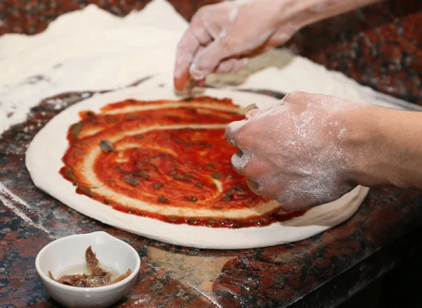 Szef kuchni przygotowanie pizzy na marmurowy stół, zbliżenie — Zdjęcie stockowe