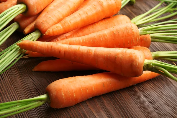Fresh organic carrots on wooden table, closeup — Stock Photo, Image