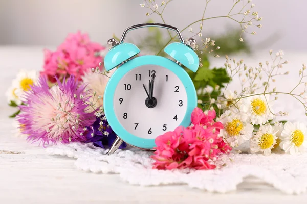 Small alarm clock with beautiful flowers — Stock Photo, Image