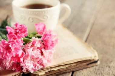 Güzel çiçekler ve çay ile eski kitap