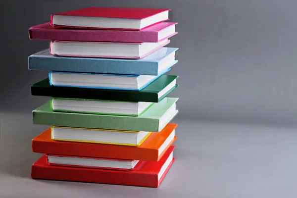 Kleurrijke boeken over grijze achtergrond — Stockfoto