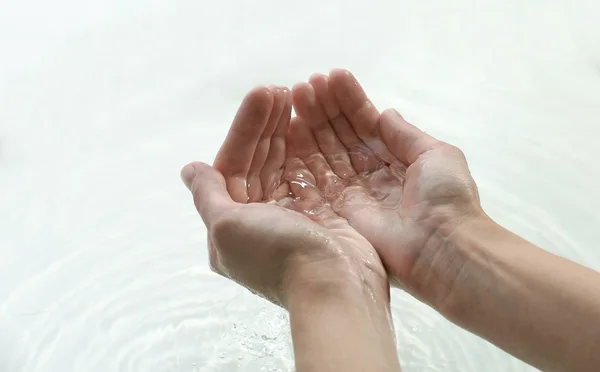 Mani femminili su sfondo acqua chiara — Foto Stock