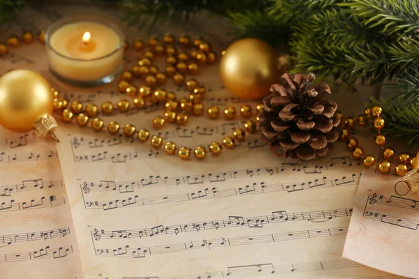 Christmas decorations on music sheets — Stock Photo, Image