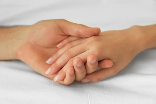 Male and female hands on white fabric background — Stock Photo, Image