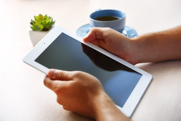 Man met digitale tablet op houten tafel achtergrond — Stockfoto