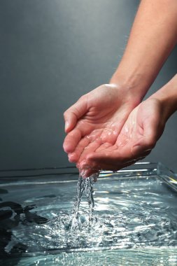 Koyu arka plan üzerine sıçramasına su ile eller