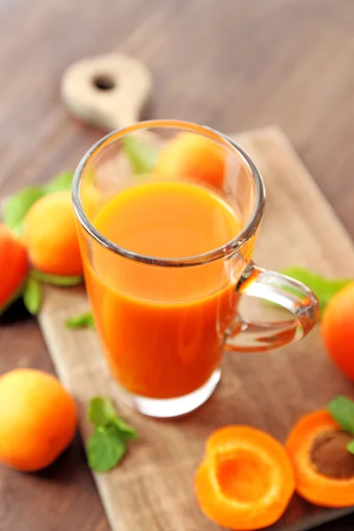Coupe en verre de jus d'abricot et de fruits frais sur la table close up — Photo