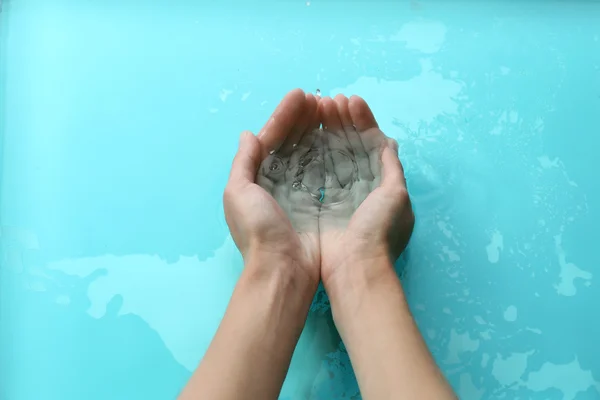 Mains féminines sur fond d'eau claire — Photo