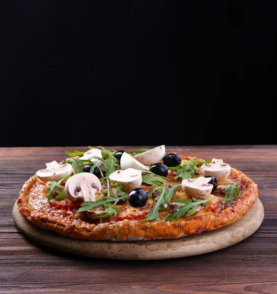 Sabrosa pizza con verduras y rúcula sobre fondo negro — Foto de Stock