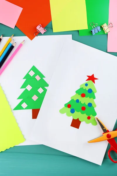 Creative paper Christmas tree on white paper sheet, scissors and colorful crayons on color table background — Stock Photo, Image