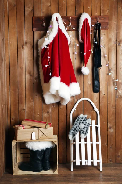 Kostým Santa, zavěšené na dřevěné stěně obrazce pozadí — Stock fotografie