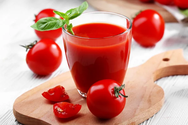 Szklanka soku pomidorowego na drewnianym stole, zbliżenie — Zdjęcie stockowe