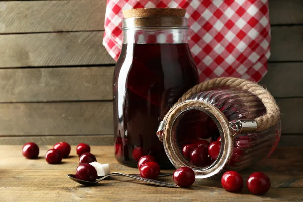 Sweet homemade cherry compote on table on wooden background — Stock Photo, Image