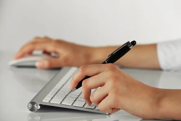 Kvinnliga händer med penna och computern mus på ljus bakgrund — Stockfoto