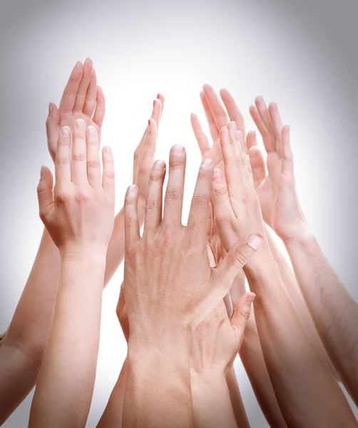 As mãos das pessoas juntas no fundo claro — Fotografia de Stock