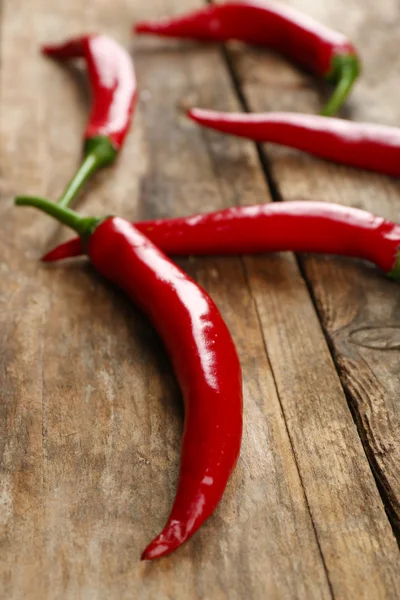 Röd varm paprika på träbord nära håll — Stockfoto