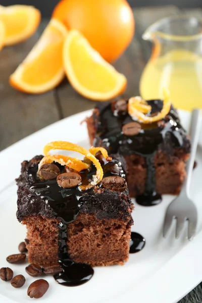 Portion of Cake with Chocolate Glaze and orange on plate, on wooden background — Stock Photo, Image