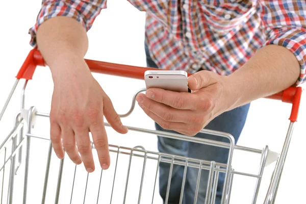 Man holding phone and shopping cart — Stock Photo, Image