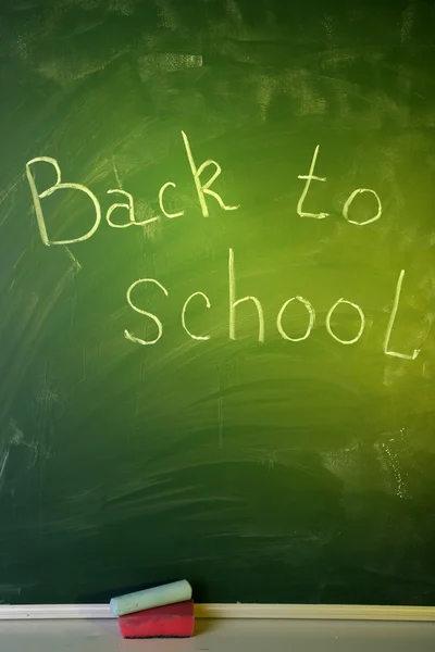 Blank blackboard with colored chalks and eraser. — Stock Photo, Image