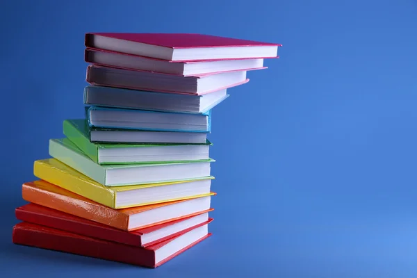 Libri colorati su sfondo blu — Foto Stock