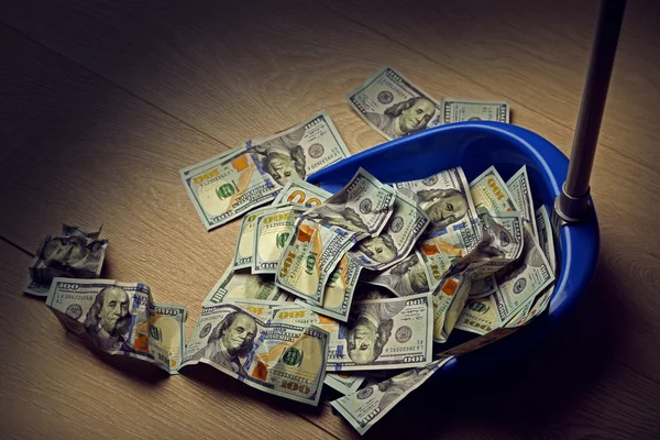 Broom sweeps dollars in garbage scoop — Stock Photo, Image