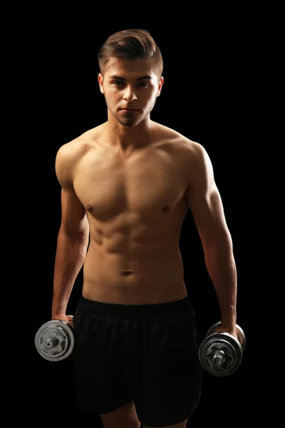 Muscle young man holding dumbbells — Stock Photo, Image