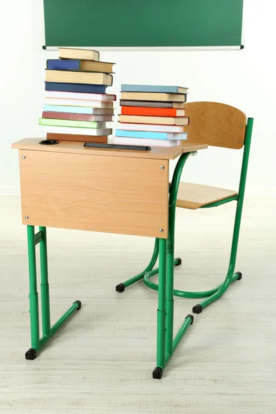 Wooden desk with books and chair in class — Stock Photo, Image