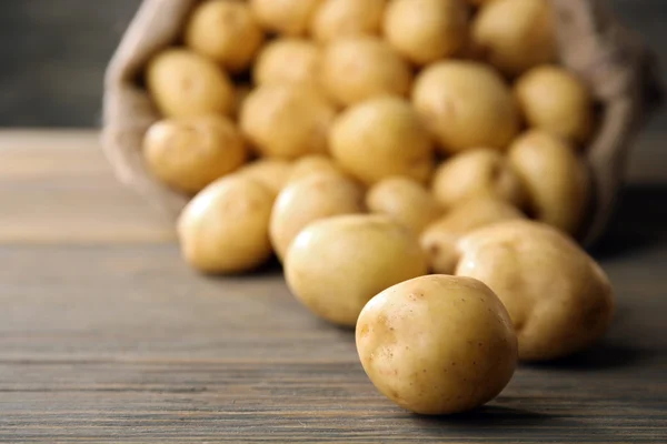 Batatas novas na mesa de madeira — Fotografia de Stock