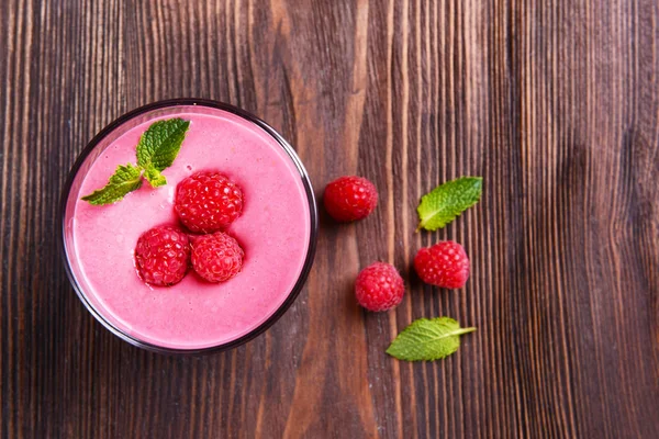 Glass of raspberry milk shake with berries