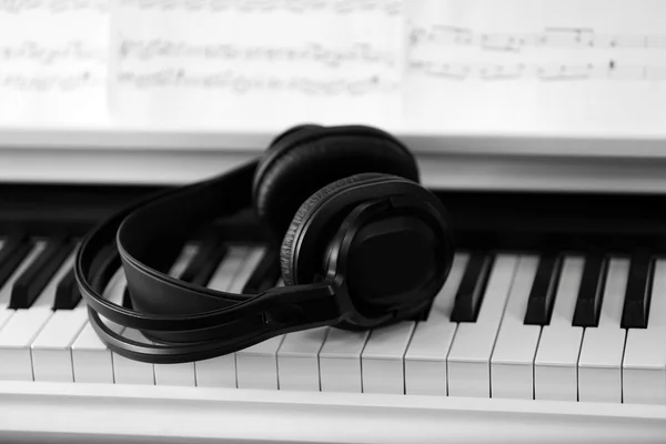 Piano con auriculares y notas musicales — Foto de Stock