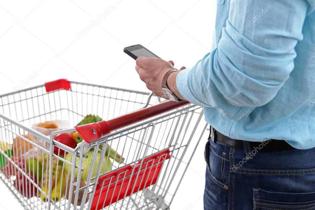 man holding phone and shopping cart