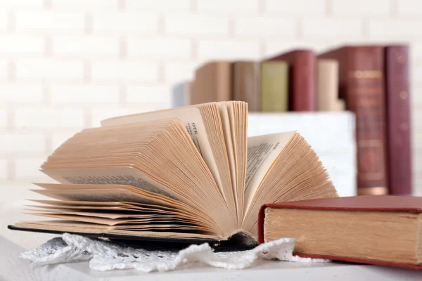 Heap de livros antigos no fundo da parede de tijolo — Fotografia de Stock