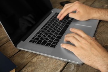 Ahşap masa üstünde laptop üzerinde çalışan adam yakın çekim