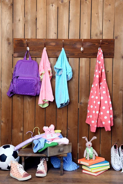 Children things hanging on wall and stacked in room — Stock Photo, Image