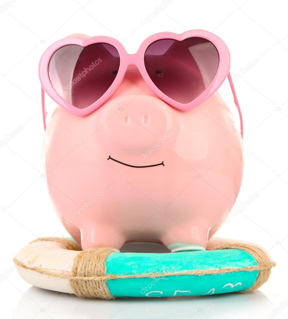 Pink piggy bank in sunglasses with lifebuoy isolated on white