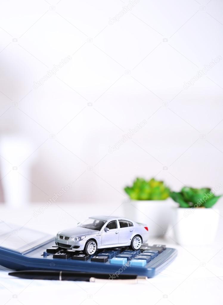 Toy car, documents and calculator on table. Car insurance concept